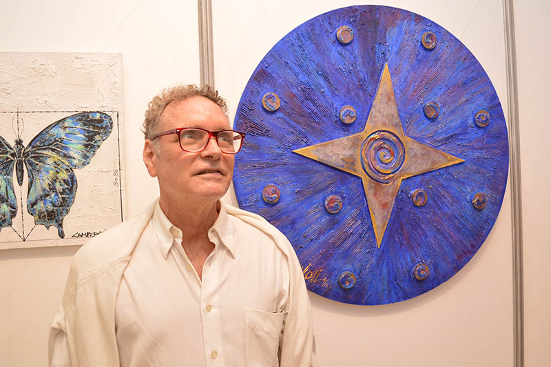 Osvaldo Camperchioli ante una de las obras que presente en una exposición en Fusión Restó donde se habilitó una pequeña galería.