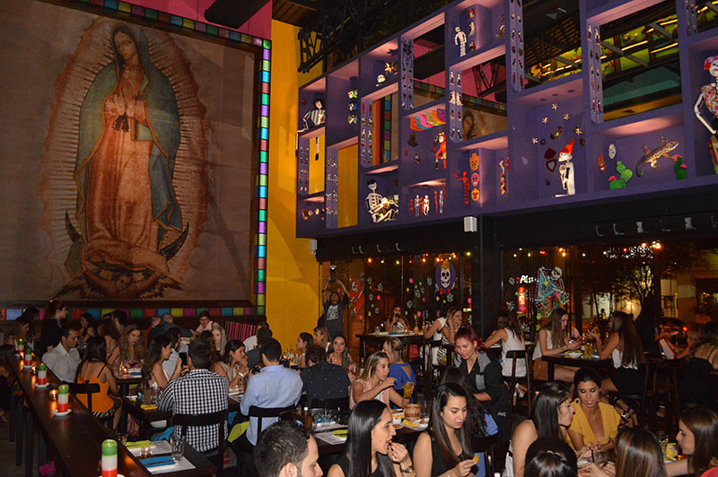 Una inmensa imagen de la Virgen de la Guadalupe domina el salón de Lupita. Colores chillones y objetos de la imaginería religiosa mexicana adornan el local.
