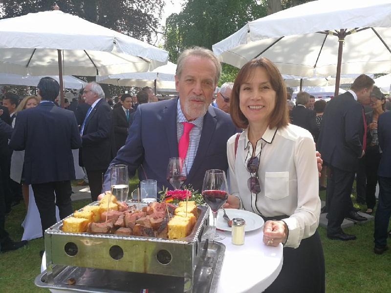 Dos de los invitados a la Fiesta Paraguaya en Berlín, posando junto a la famosa parrillita, todo un símbolo de la gastronomía paraguaya.