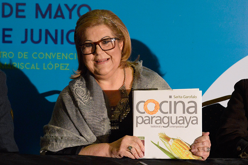 Sarita Garofalo exhibiendo la portada de su libro, cuya segunda edición se presentó durante la Feria Internacional del Libro.