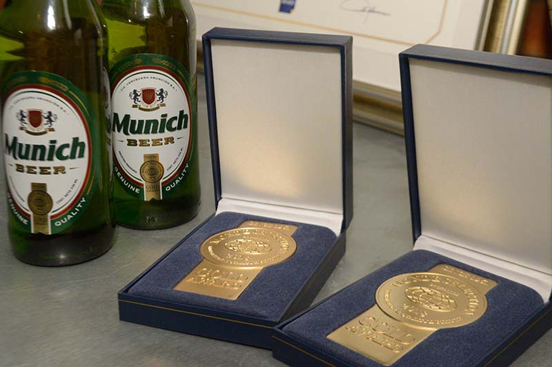 En primer plano la medalla de oro que recibió la cerveza Munich, junto a la botella con el nuevo packaging que aparecerá a fines de agosto.