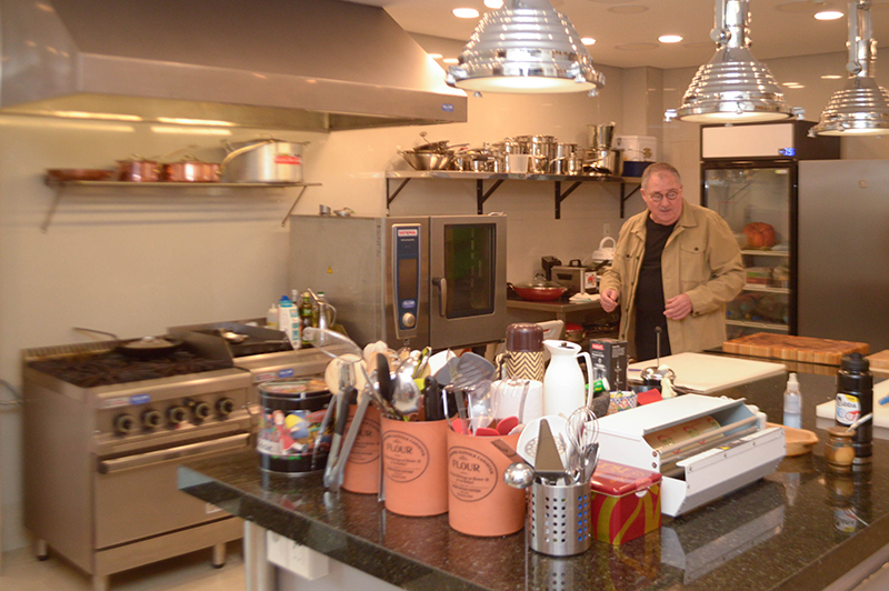 Chef Papá Marcos en medio de su cocina. Tiene todos los equipos que se precisan para elaborar cualquier tipo de plato.