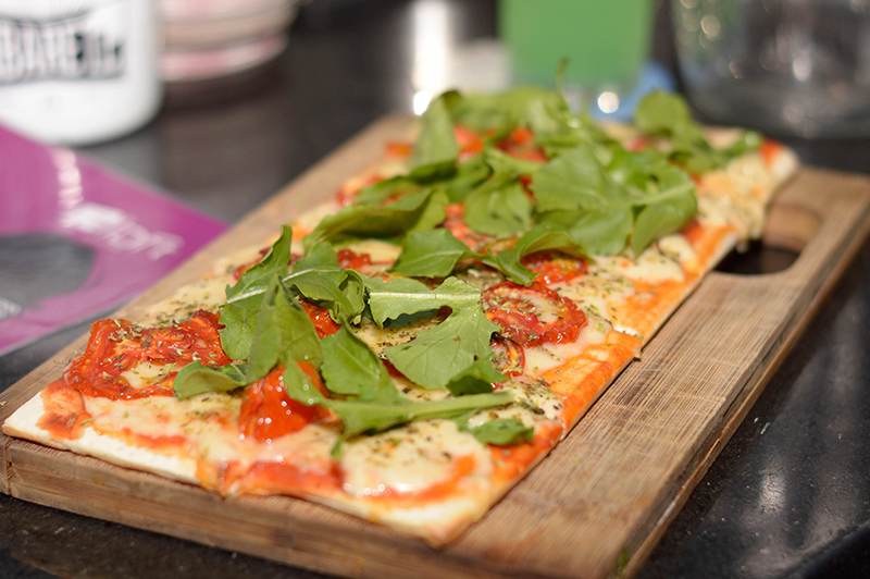 La pizza de muzzarella, salsa de tomate, tomate seco y rúcula, una de las tantas opciones gastronómicas. Tambien hay picadas y sandwiches.