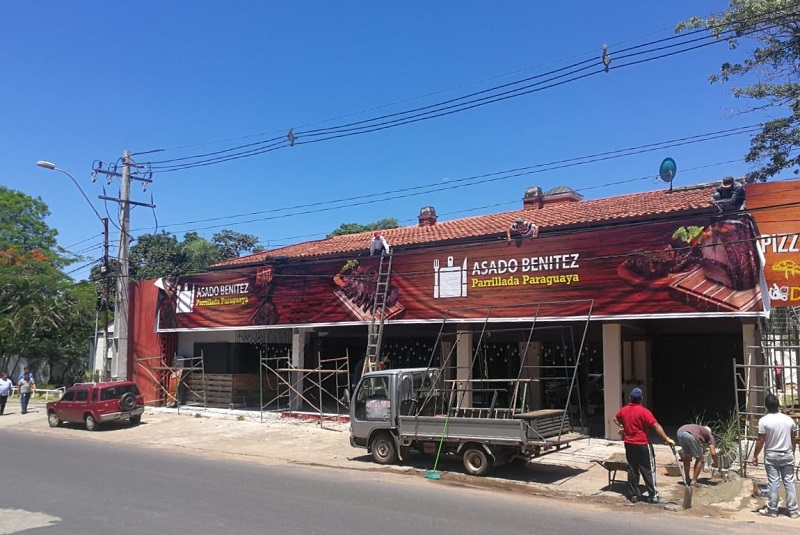 Sorprendimos a los trabajadores, en el momento en que estaban colocando el gran cartel para la parrillada de Asado Benítez, sobre Aviadores del Chaco.