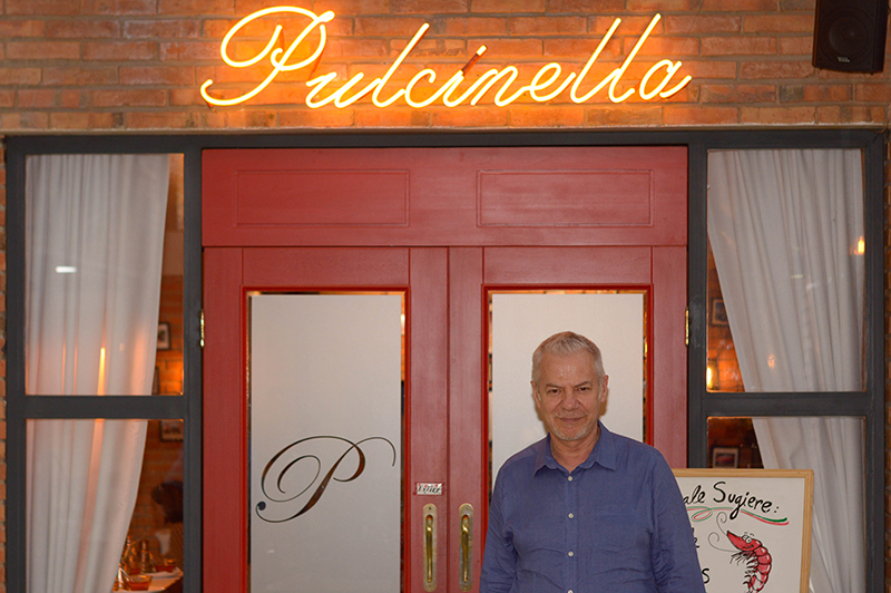 Pasquale Maione, creador y propietario de la pizzería Pulcinella posando frente a la entrada de su local.