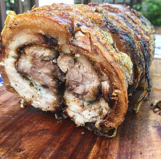 Una tradicional porchetta italiana, carne de cerdo arrollada y asada al horbo, adobada con diversas hierbas.