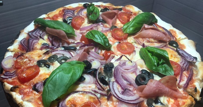 Zampano: Pizza al tatakua, pomodoro, mozzarella, cebolla morada, aceitunas negras, tomates Cherry y albahaca fresca.
